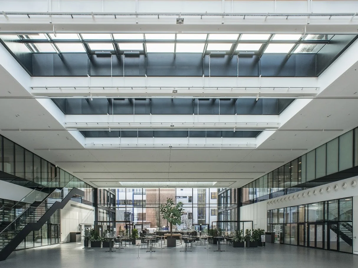 WIKA Alexander Wiegand SE & Co. KG WIKA modern office atrium with glass roof, open workspace, and seating area for collaboration