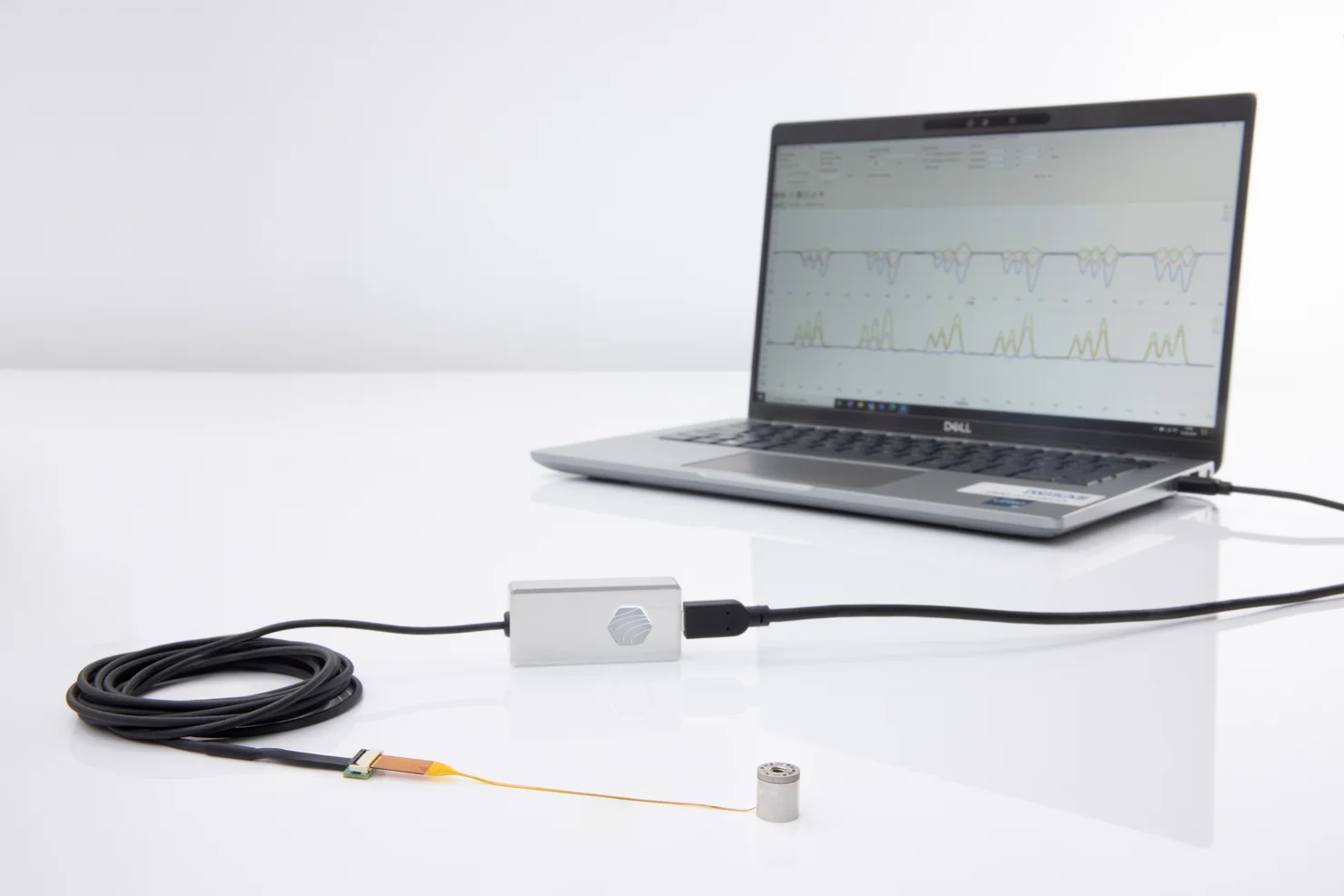 Miniature force torque sensor connected to evaluation unit with laptop displaying measurement data