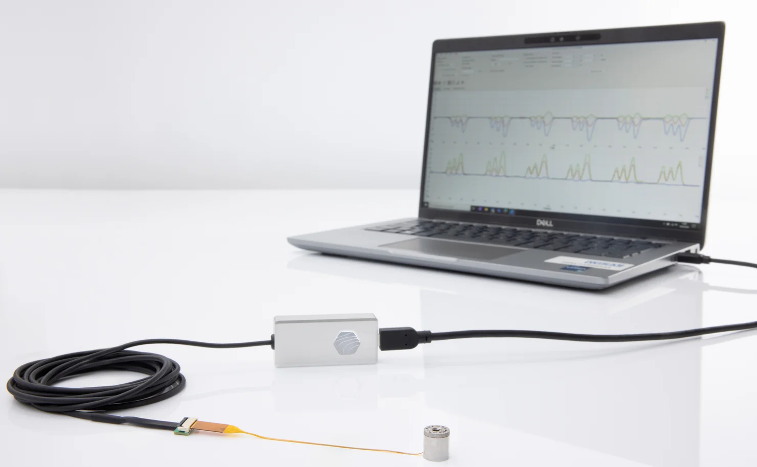 Miniature force torque sensor connected to evaluation unit with laptop displaying measurement data
