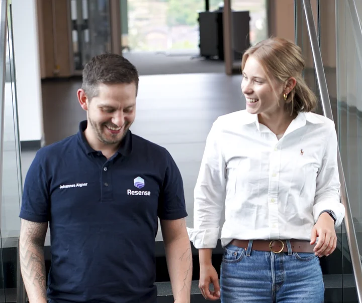 Two employees walking down office stairs in modern workspace environment