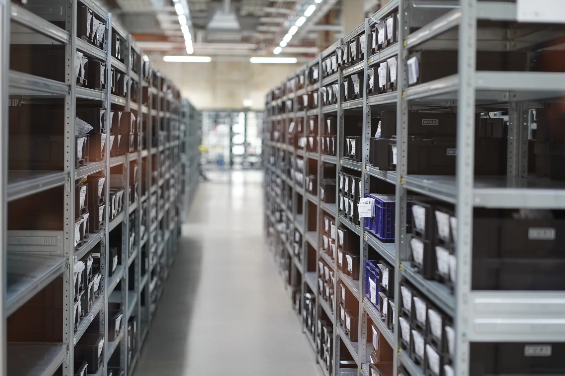 Industrial storage racks with labeled containers in organized warehouse environment for component handling
