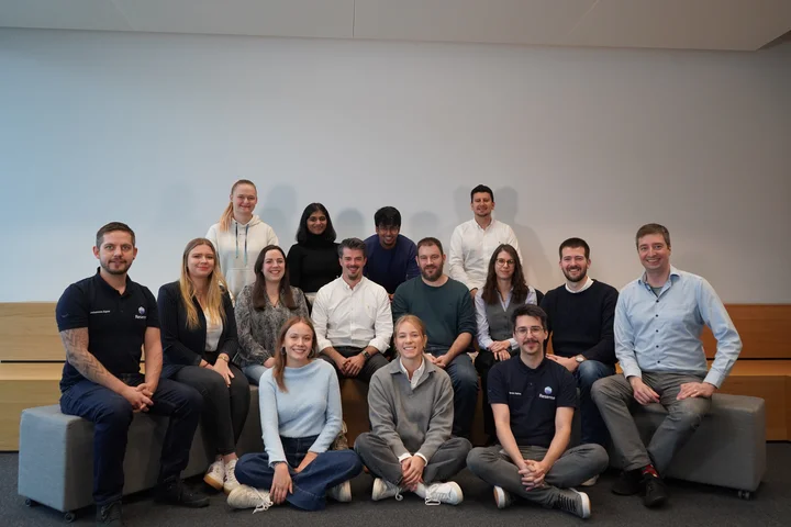 Resense team group photo in office setting showing employees seated and standing in modern workspace